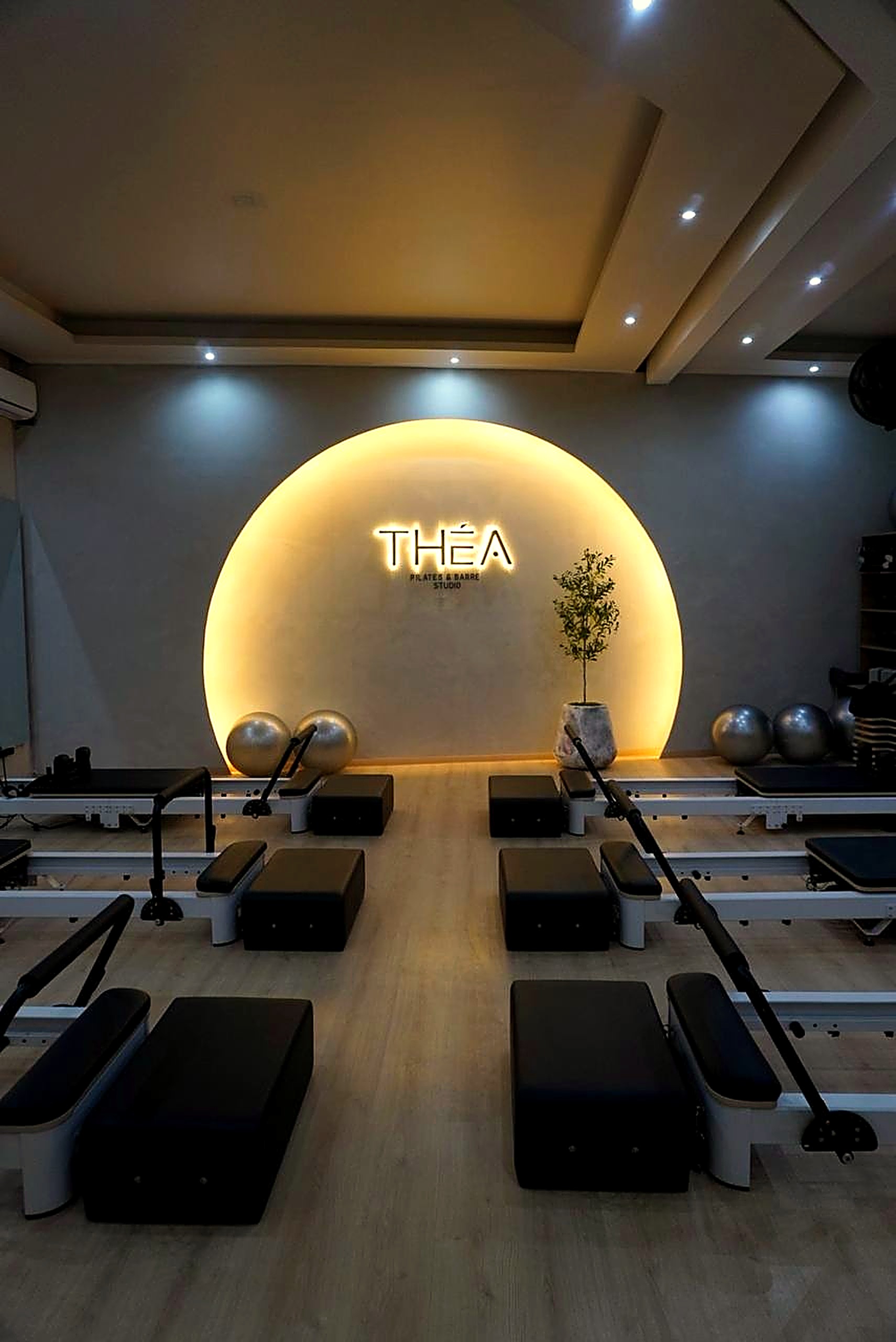 Sala de Pilates Reformer con letrero de neón THÉA