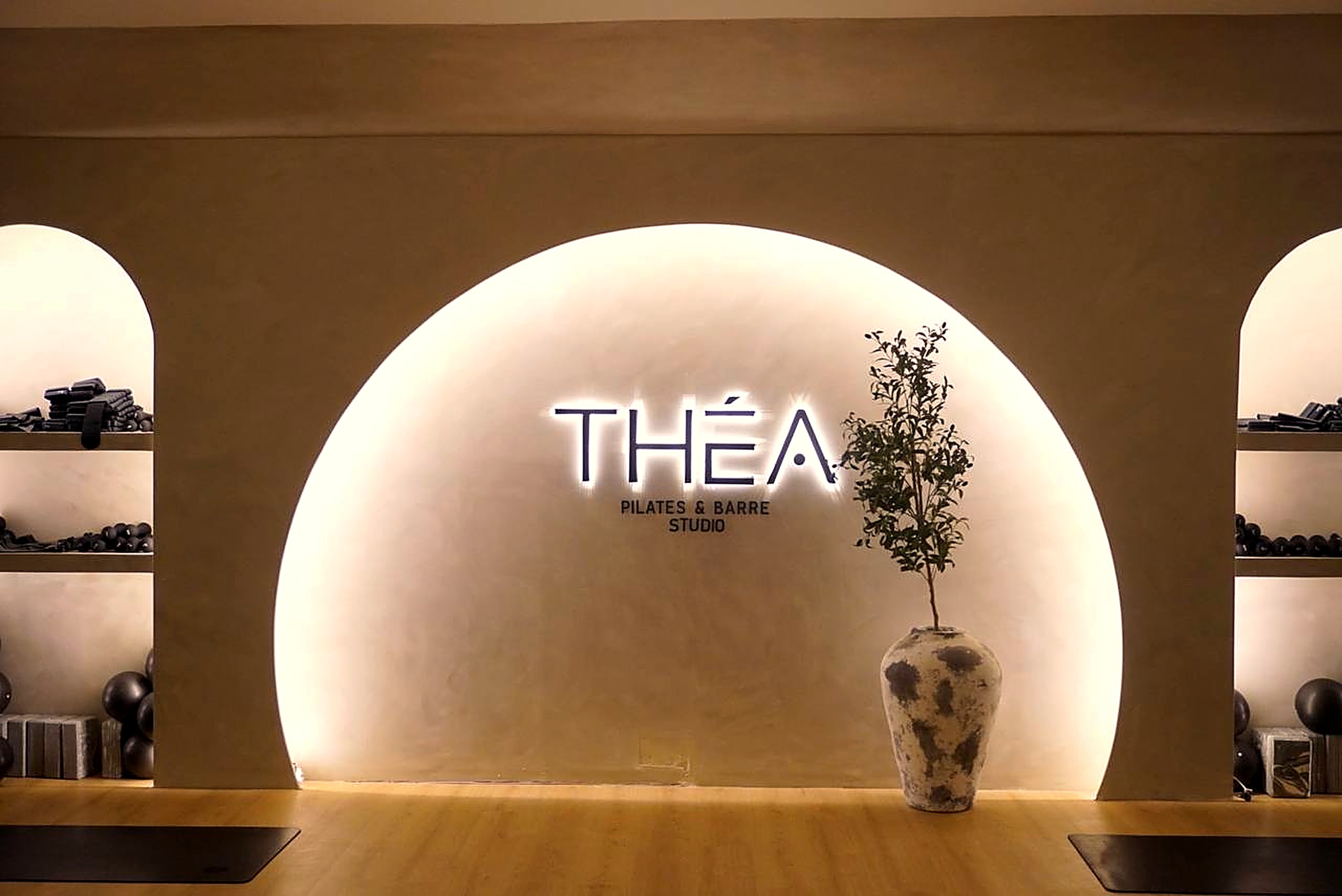 Recepción de Théa Studio con logo de neón THÉA